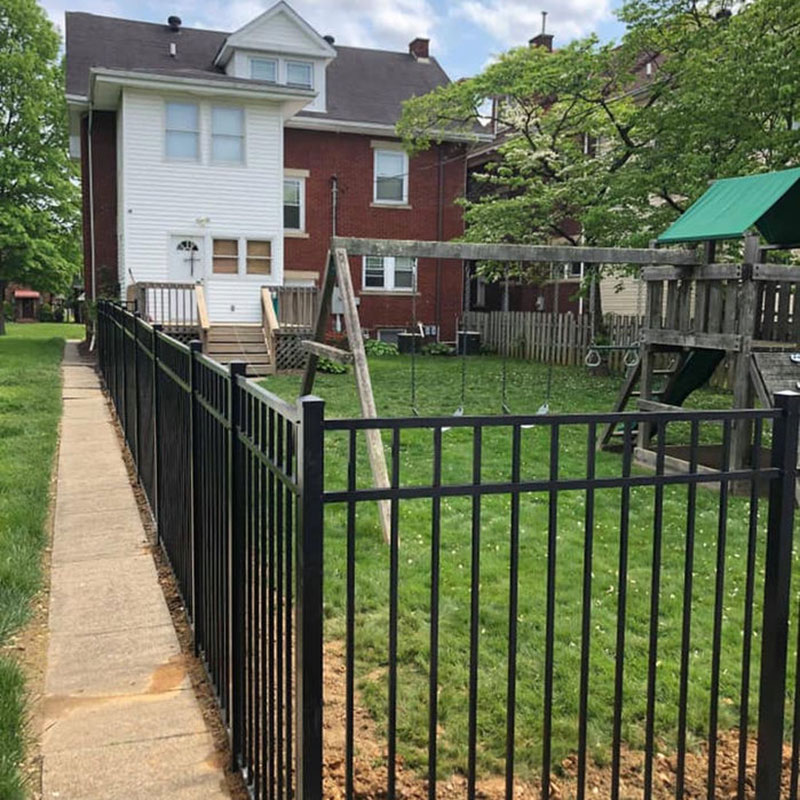 Black ornamental aluminum fence along a sidewalk