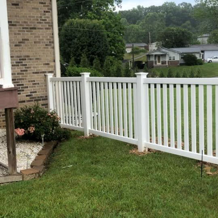 White vinyl picket fence along a side yard